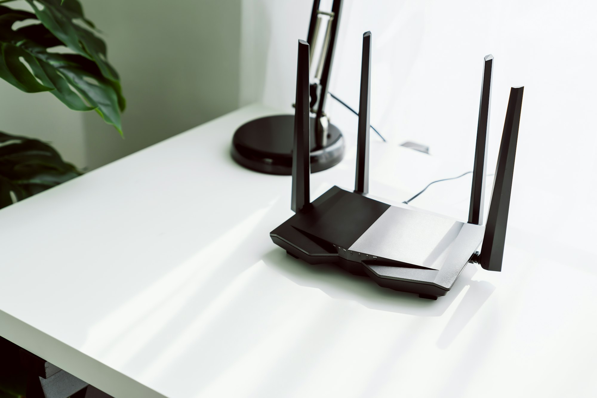 Wifi and broadband router on white table in room at the home.